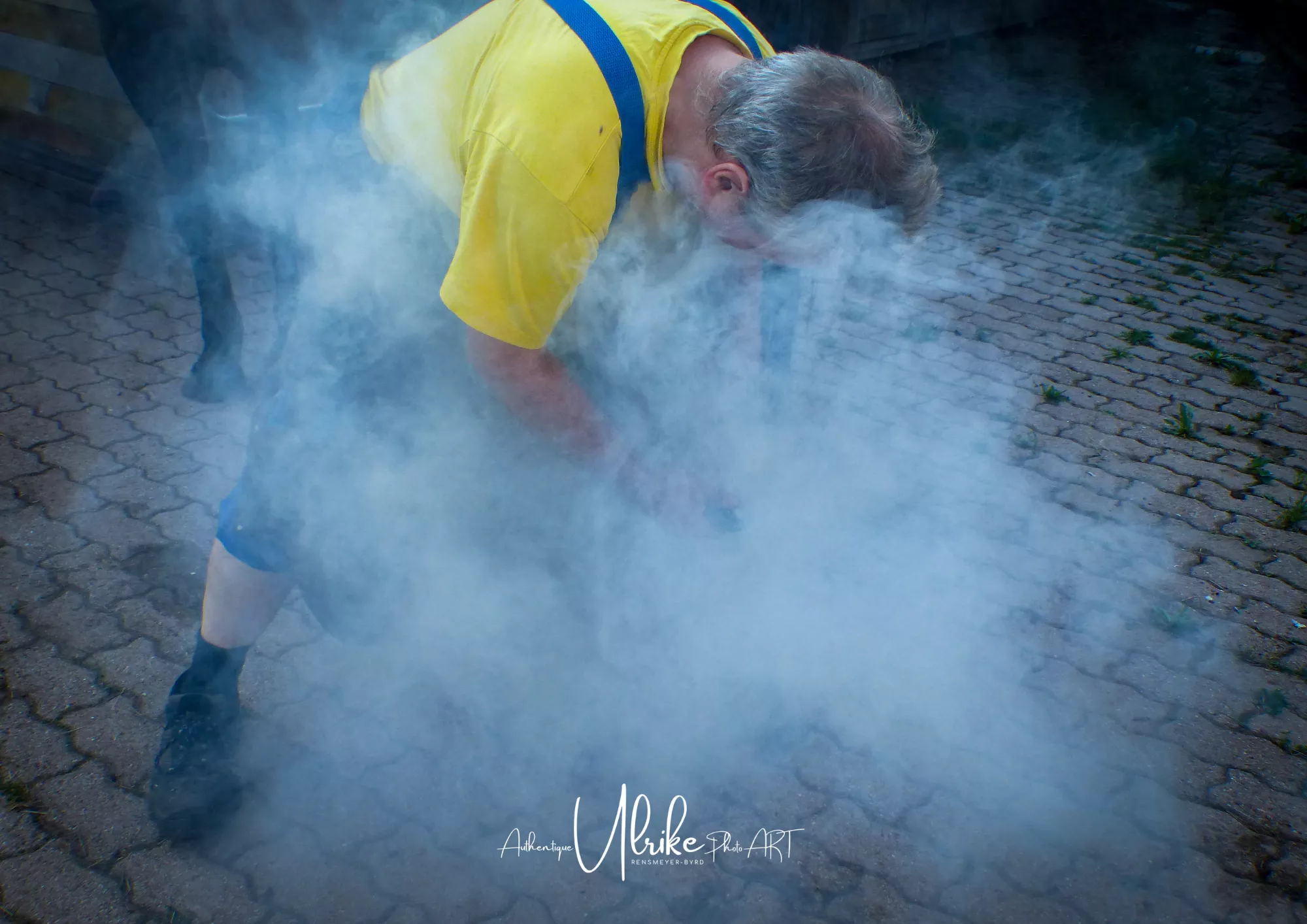 Mann bei der Arbeit, kaum sichtbar durch Rauch/Nebel