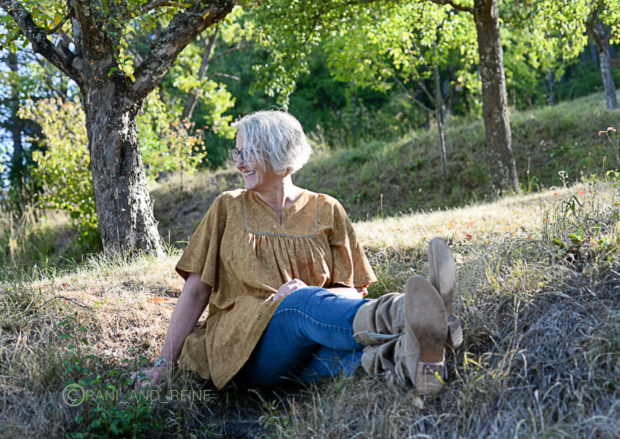 Ulrike mitten in der Natur sitzend, nach rechts schauend
